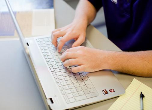 close up view of hands typing on a laptop